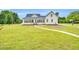 Exterior view of the home showing the white siding, blue roof, many windows, and well-maintained lawn at 750 James Norris Rd, Angier, NC 27501