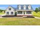 Charming home featuring a welcoming front porch, black shutters, and manicured landscaping at 750 James Norris Rd, Angier, NC 27501