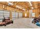 Large garage with unfinished walls, three garage doors, lawn equipment, and an adjacent window at 750 James Norris Rd, Angier, NC 27501