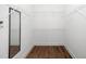 Bright, walk-in closet featuring an abundance of built-in shelving, and wood flooring at 7805 Tuscan Ridge Dr, Wendell, NC 27591