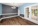 Formal dining room with modern chandelier, chair railing, wood flooring, and access to the back deck at 7805 Tuscan Ridge Dr, Wendell, NC 27591