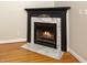 Elegant fireplace featuring marble surround, black mantel and hardwood flooring at 7805 Tuscan Ridge Dr, Wendell, NC 27591