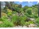 Serene pond with cascading waterfall, lush plants, and rock accents, creating a tranquil backyard retreat at 7805 Tuscan Ridge Dr, Wendell, NC 27591
