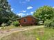 Charming single-story brick home surrounded by mature trees and a grassy yard at 80 Dunn Rd, Louisburg, NC 27549