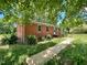 Charming single-story brick home with inviting front entrance and lush surrounding greenery at 80 Dunn Rd, Louisburg, NC 27549