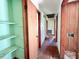 Hallway with hardwood floors, storage shelving, and multiple doorways at 80 Dunn Rd, Louisburg, NC 27549