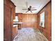 Vintage-style kitchen with wood paneling, a ceiling fan, and a small window at 80 Dunn Rd, Louisburg, NC 27549