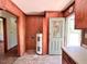 A utility room with wood paneled walls, door to the backyard, water heater, and laminate countertops at 80 Dunn Rd, Louisburg, NC 27549