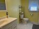 Bright bathroom features a white toilet and sink, with a metal storage rack at 8019 W Tarboro Rd, Rocky Mount, NC 27803
