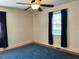 Bedroom with natural light features hardwood floors, ceiling fan, and blue curtains at 8019 W Tarboro Rd, Rocky Mount, NC 27803