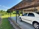 An open carport area and parked white car with green scenery in the background at 8019 W Tarboro Rd, Rocky Mount, NC 27803