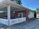 This brick home features an attached covered area with a white picket fence at 8019 W Tarboro Rd, Rocky Mount, NC 27803