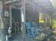 Backyard shed with a covered porch and rocking chairs at 8019 W Tarboro Rd, Rocky Mount, NC 27803