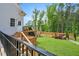 Backyard with a fenced in in-ground pool, grassy lawn, mature trees, and wooden deck with railing at 808 Wimberly Rd, Apex, NC 27523