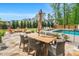Outdoor patio area with dining and backyard views, pool, fire pit, and lounge chairs; surrounded by lush landscaping at 808 Wimberly Rd, Apex, NC 27523