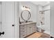 Bathroom featuring a vanity with granite counters, framed round mirror and a shower with marble tile at 808 Wimberly Rd, Apex, NC 27523