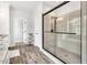 Spacious bathroom featuring a glass enclosed shower with tile surround, modern fixtures, and wood-look floors at 808 Wimberly Rd, Apex, NC 27523