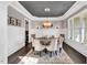 Formal dining room with wainscoting, tray ceiling, elegant chandelier, and large window offering ample light at 808 Wimberly Rd, Apex, NC 27523