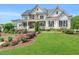 Stunning two-story home featuring a manicured lawn, stone accents, and a welcoming wrap-around front porch at 808 Wimberly Rd, Apex, NC 27523