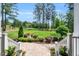 Inviting front yard with stone walkway and stairs, lush plants and trees, and a view of the expansive lawn at 808 Wimberly Rd, Apex, NC 27523