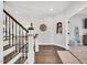 Hallway with hardwood floors, white walls, staircase with dark wood and iron railing, and decorative niches at 808 Wimberly Rd, Apex, NC 27523