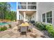 Back patio with flagstone flooring, features outdoor dining area with views of the pool and manicured backyard at 808 Wimberly Rd, Apex, NC 27523