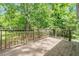 Wooden back deck with brown wooden railings overlooking a grassy backyard with mature trees at 81 Honeysuckle Dr, Pittsboro, NC 27312
