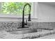 Close up of stainless steel sink, black faucet, and speckled countertops at 81 Honeysuckle Dr, Pittsboro, NC 27312