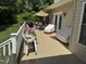 Outdoor deck with ample seating options, a grill, and an umbrella for shade overlooking a lush yard at 84 Macbeth Ln, Roxboro, NC 27574