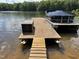 A wooden boat dock extends into the lake, offering a tranquil spot for relaxation and access to water activities at 84 Macbeth Ln, Roxboro, NC 27574