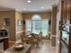 Bright breakfast nook area with a large window, complemented by wicker chairs and tile flooring at 84 Macbeth Ln, Roxboro, NC 27574