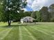 Charming one-story home with manicured lawn, two-car garage, and a lush wooded backdrop at 84 Macbeth Ln, Roxboro, NC 27574