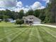 Charming one-story home with manicured lawn, two-car garage, and front porch with chairs and a jet ski at 84 Macbeth Ln, Roxboro, NC 27574