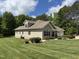 Beautifully landscaped yard complements this tan two-story house, complete with an attached garage and lush greenery at 84 Macbeth Ln, Roxboro, NC 27574