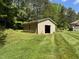 Exterior view of a detached outbuilding or storage shed in a well-maintained yard at 84 Macbeth Ln, Roxboro, NC 27574