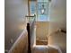 View of a staircase featuring hardwood steps, white banister, and transom window overlooking the backyard at 84 Macbeth Ln, Roxboro, NC 27574