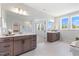 This bathroom has and wooden vanities with quartz counters, framed mirrors, and windows at 8416 Brady Pointe Rd, Fuquay Varina, NC 27526
