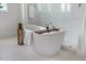 Modern bathroom featuring a freestanding tub, glass-enclosed shower, and neutral tones at 8416 Brady Pointe Rd, Fuquay Varina, NC 27526