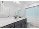 Contemporary bathroom with dark vanity, quartz countertop, modern fixtures, and shower with curtain at 8416 Brady Pointe Rd, Fuquay Varina, NC 27526
