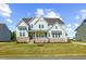Beautiful two-story home featuring stone accents, light blue siding, and a welcoming front porch at 8416 Brady Pointe Rd, Fuquay Varina, NC 27526