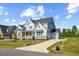 Spacious two-story home with a three-car garage, well-kept landscaping, and stylish architectural details at 8416 Brady Pointe Rd, Fuquay Varina, NC 27526