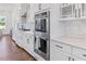 Kitchen featuring stainless steel appliances, including a double oven and modern white cabinets at 8416 Brady Pointe Rd, Fuquay Varina, NC 27526