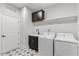 This laundry room features a cabinet, shelves, a washer, and a dryer with mosaic tile floors at 8416 Brady Pointe Rd, Fuquay Varina, NC 27526