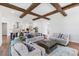 Comfortable living room featuring hardwood floors, wooden beams, and an open floor plan with a modern kitchen at 8416 Brady Pointe Rd, Fuquay Varina, NC 27526
