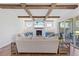 Comfortable living room with exposed beams, brick fireplace, and large sliding doors to the porch at 8416 Brady Pointe Rd, Fuquay Varina, NC 27526