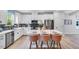 Bright kitchen featuring white cabinets, stainless steel appliances, an island with seating, and stylish backsplash at 8728 Wardle Ct, Wake Forest, NC 27587