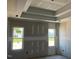 Main bedroom with a tray ceiling and windows overlooking the backyard at 91 Retreat Run, Smithfield, NC 27577