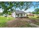 Quaint white house has a brick chimney and a spacious backyard with room for outdoor activities at 1012 Rainey St, Burlington, NC 27217