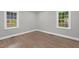 Light-filled bedroom with wood floors, two windows, and a neutral color scheme at 1012 Rainey St, Burlington, NC 27217