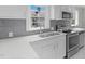 Updated kitchen featuring stainless steel appliances, white cabinets, and sleek countertops at 1012 Rainey St, Burlington, NC 27217